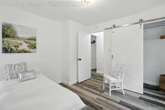8411 Hugh St, Westland, MI 48185 - bedroom featuring a barn door, wood finished floors, and a closet