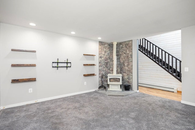 2931 N Lake Pleasant Rd, Attica, MI 48412 - unfurnished living room featuring a baseboard radiator, a wood stove, carpet floors, stairs, and recessed lighting