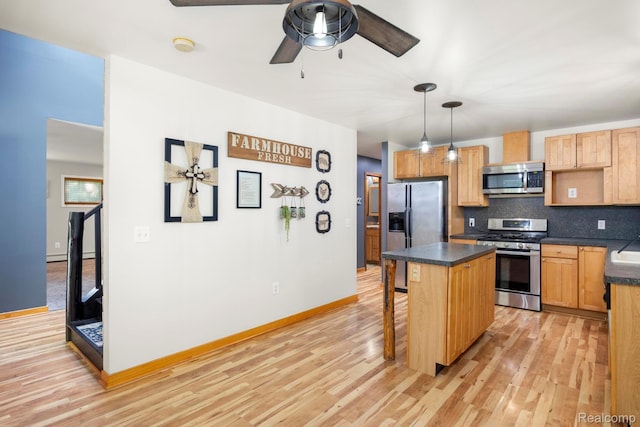 2931 N Lake Pleasant Rd, Attica, MI 48412 - kitchen with appliances with stainless steel finishes, dark countertops, tasteful backsplash, light wood-style floors, and a center island