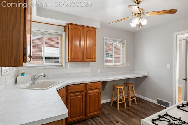 8639 Alper St, Westland, MI 48185 - kitchen with dark wood-style flooring, brown cabinetry, light countertops, and ceiling fan