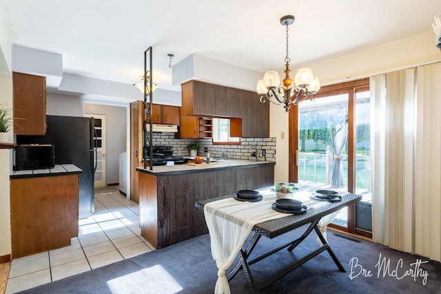 3541 Orshal Rd, Whitehall, MI 49461 - kitchen with a peninsula, black range with electric stovetop, a chandelier, backsplash, and under cabinet range hood