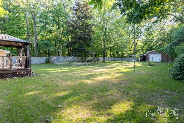 3541 Orshal Rd, Whitehall, MI 49461 - fenced backyard featuring a gazebo, a wooden deck, a detached garage, an outbuilding, and an outdoor structure