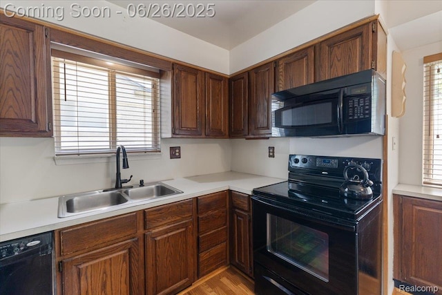 1070 Dreon Dr, Clawson, MI 48017 - kitchen with black appliances, light countertops, plenty of natural light, and light wood-style floors