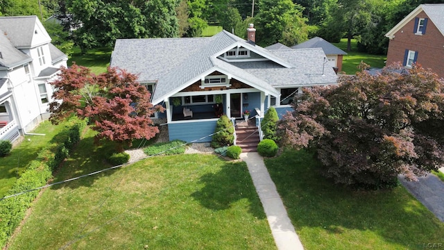 950 College Ave, Adrian, MI 49221 - view of front of property with a porch, a chimney, a front lawn, and a shingled roof