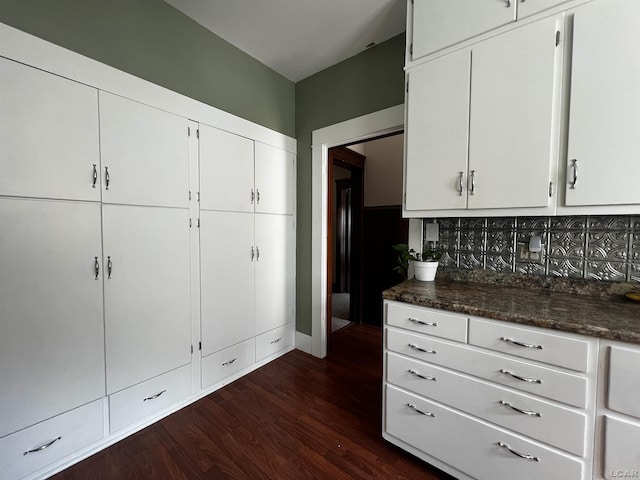 950 College Ave, Adrian, MI 49221 - kitchen featuring dark wood finished floors, dark countertops, decorative backsplash, and white cabinets
