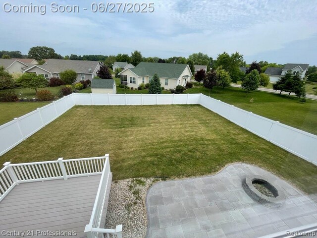 8090 Majestic Blvd, Fowlerville, MI 48836 - fenced backyard with a residential view, a fire pit, a patio, and a wooden deck