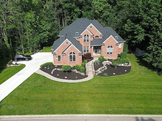 8255 Shady Brook Ln, Flushing, MI 48433 - view of front of home featuring concrete driveway, a front yard, brick siding, and a wooded view