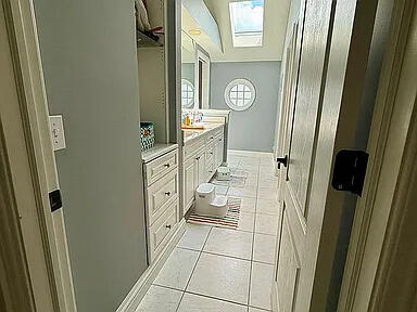 8255 Shady Brook Ln, Flushing, MI 48433 - bathroom featuring vanity, tile patterned flooring, and a skylight