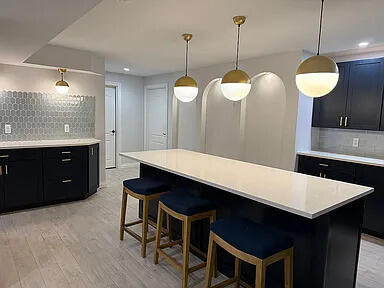 8255 Shady Brook Ln, Flushing, MI 48433 - kitchen with dark cabinets, tasteful backsplash, light countertops, a breakfast bar, and recessed lighting