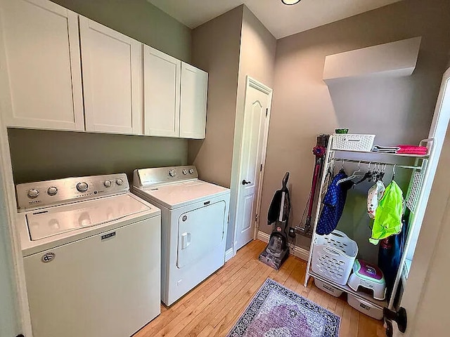 8255 Shady Brook Ln, Flushing, MI 48433 - washroom with light wood-style floors, washing machine and clothes dryer, and cabinet space