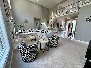 8255 Shady Brook Ln, Flushing, MI 48433 - living area featuring a high ceiling, stairs, decorative columns, and carpet floors