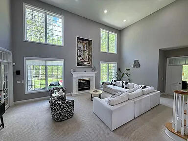 8255 Shady Brook Ln, Flushing, MI 48433 - living room featuring a towering ceiling, carpet, a glass covered fireplace, and recessed lighting
