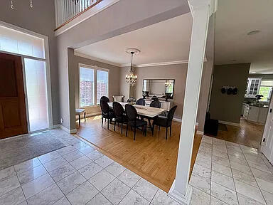 8255 Shady Brook Ln, Flushing, MI 48433 - dining room featuring light tile patterned floors, ornamental molding, and a chandelier