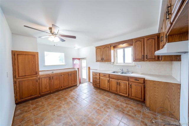 17213 Anne Ave, Detroit, MI 48101 - kitchen with brown cabinetry, ceiling fan, light countertops, and under cabinet range hood