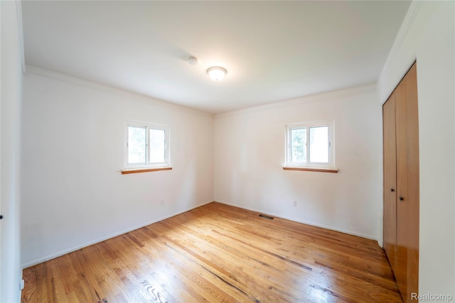 17213 Anne Ave, Detroit, MI 48101 - unfurnished bedroom featuring multiple windows, crown molding, wood finished floors, and a closet