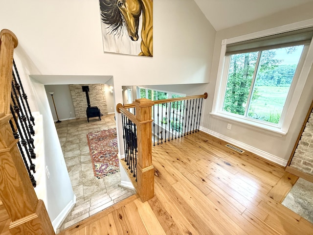 13955 Rattalee Lake Rd, Davisburg, MI 48350 - staircase featuring a wood stove, wood-type flooring, and lofted ceiling