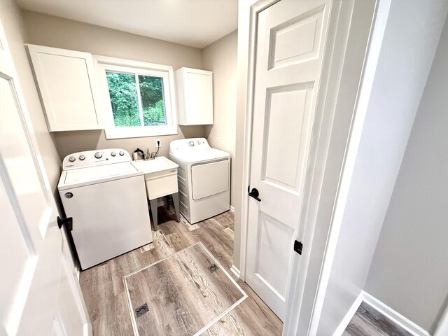 13955 Rattalee Lake Rd, Davisburg, MI 48350 - laundry room featuring cabinet space, washing machine and clothes dryer, and light wood-style floors