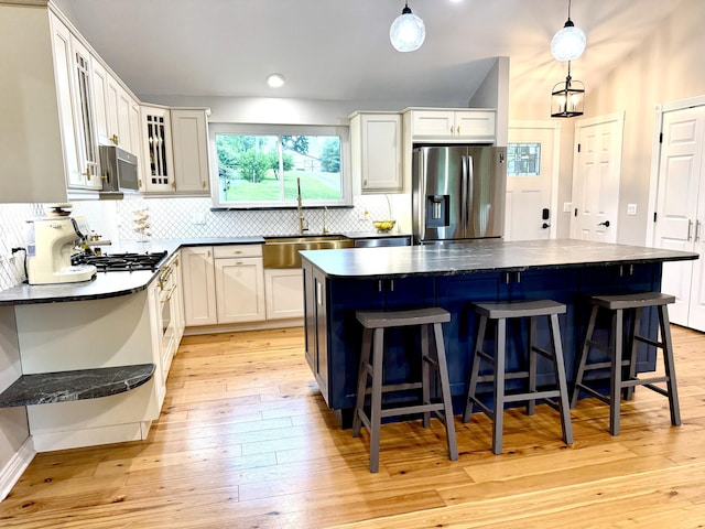13955 Rattalee Lake Rd, Davisburg, MI 48350 - kitchen with appliances with stainless steel finishes, backsplash, and a kitchen breakfast bar