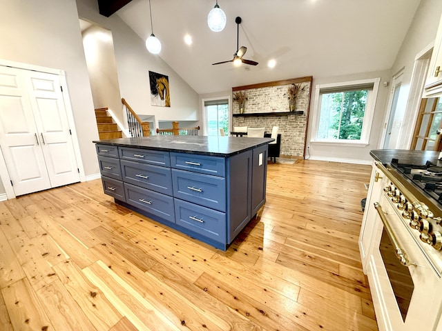 13955 Rattalee Lake Rd, Davisburg, MI 48350 - kitchen featuring ceiling fan, a fireplace, plenty of natural light, light wood-style flooring, and high vaulted ceiling
