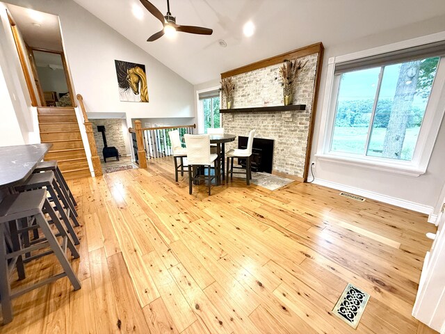 13955 Rattalee Lake Rd, Davisburg, MI 48350 - living area with a brick fireplace, hardwood / wood-style floors, ceiling fan, vaulted ceiling, and stairway
