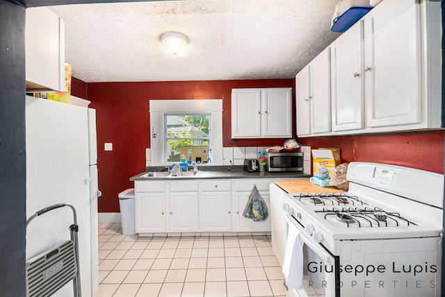 612 Norman St, Lansing, MI 48910 - kitchen featuring white appliances, light tile patterned floors, white cabinets, and a textured ceiling