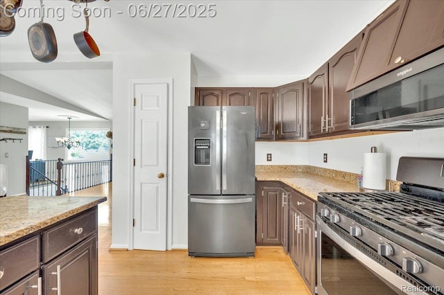 1522 Oregon Ct, Waterford, MI 48327 - kitchen featuring stainless steel appliances, a chandelier, light wood-style floors, and dark brown cabinets