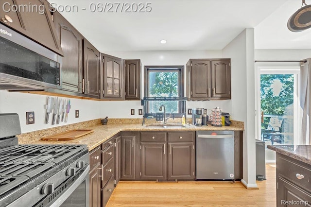 1522 Oregon Ct, Waterford, MI 48327 - kitchen with stainless steel appliances, dark brown cabinetry, light wood-style flooring, and light stone countertops