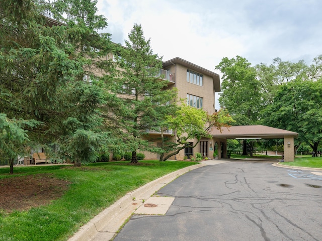 4040 Greenleaf Cir Unit 108, Kalamazoo, MI 49008 - view of building exterior featuring a carport and asphalt driveway