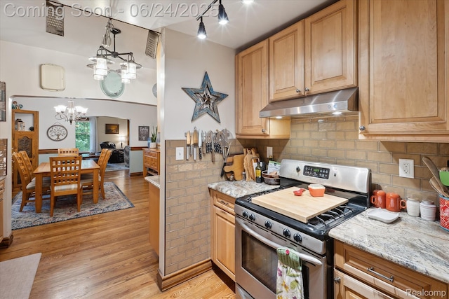 8450 Rosbolt Rd, Willis, MI 48191 - kitchen featuring stainless steel stove, under cabinet range hood, a chandelier, light wood-style floors, and wainscoting
