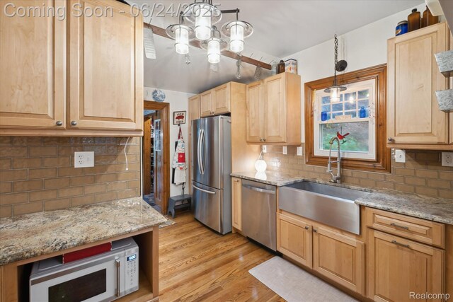 8450 Rosbolt Rd, Willis, MI 48191 - kitchen with stainless steel appliances, light brown cabinets, and tasteful backsplash