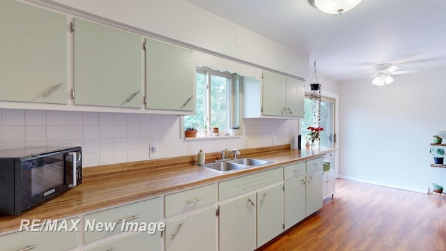 5071 Heidi Ln, Saginaw, MI 48604 - kitchen with black microwave, backsplash, ceiling fan, and plenty of natural light