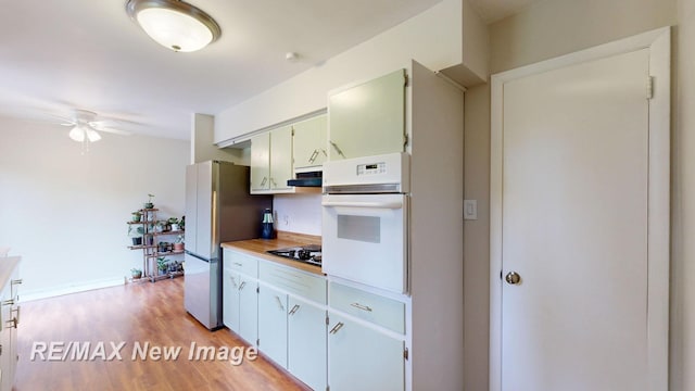 5071 Heidi Ln, Saginaw, MI 48604 - kitchen featuring white appliances, ceiling fan, light wood-style flooring, extractor fan, and light countertops