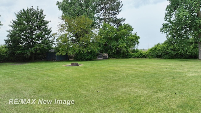 5071 Heidi Ln, Saginaw, MI 48604 - view of grassy yard with an outbuilding and a fire pit