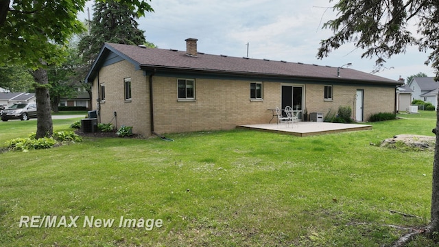 5071 Heidi Ln, Saginaw, MI 48604 - rear view of house featuring a chimney, a yard, brick siding, a patio area, and a deck