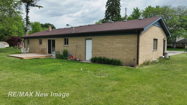 5071 Heidi Ln, Saginaw, MI 48604 - back of property featuring a deck, brick siding, a lawn, and a storage unit