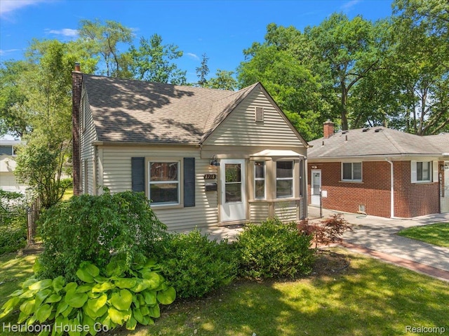 2718 Hubbard St, Dearborn, MI 48124 - view of front of house with a chimney, brick siding, and a shingled roof