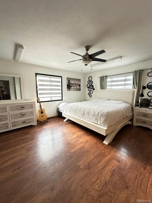 4502 E Wilkinson Rd, Owosso, MI 48867 - bedroom featuring a textured ceiling, dark wood-style flooring, and ceiling fan