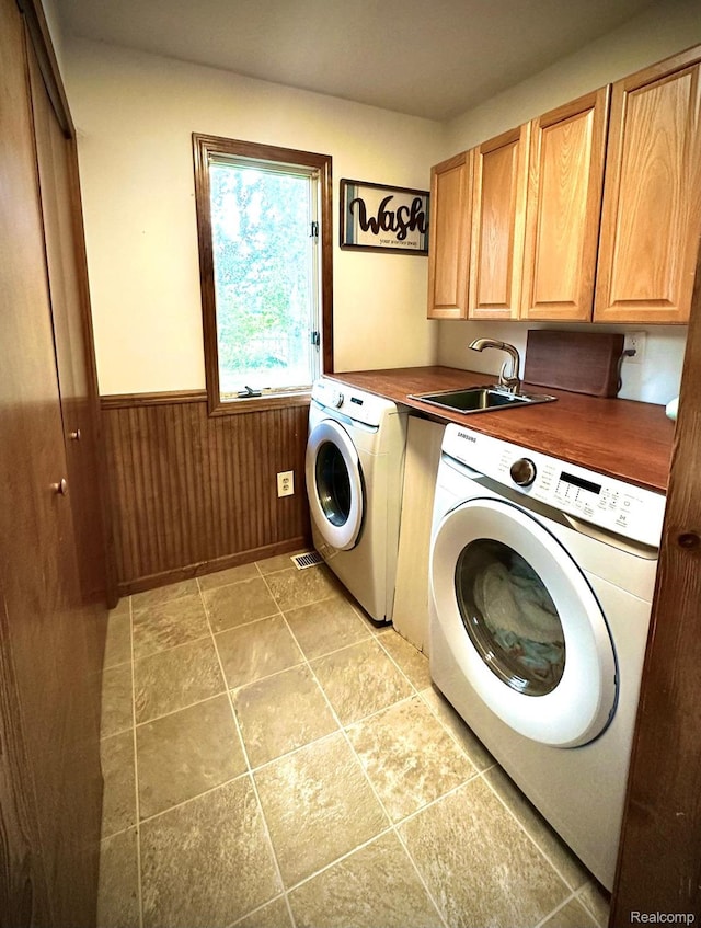4502 E Wilkinson Rd, Owosso, MI 48867 - laundry area with cabinet space, separate washer and dryer, a wainscoted wall, and wood walls