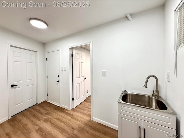 2526 Genes Dr, West Bloomfield, MI 48326 - laundry room featuring light wood-style flooring and cabinet space
