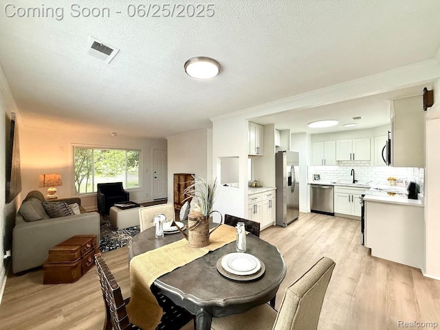 2526 Genes Dr, West Bloomfield, MI 48326 - dining area featuring light wood-style floors and a textured ceiling
