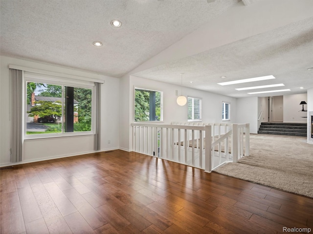 5620 Eastman Blvd, West Bloomfield, MI 48323 - empty room with a textured ceiling, a skylight, plenty of natural light, wood finished floors, and lofted ceiling