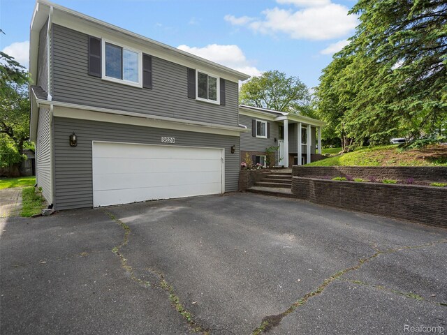 5620 Eastman Blvd, West Bloomfield, MI 48323 - view of front of house with an attached garage and asphalt driveway