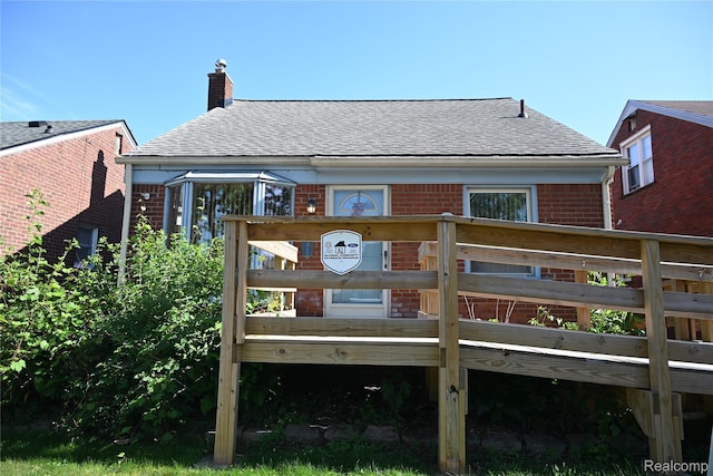 1431 Moran Ave, Lincoln Park, MI 48146 - back of house with brick siding, roof with shingles, a chimney, and a deck