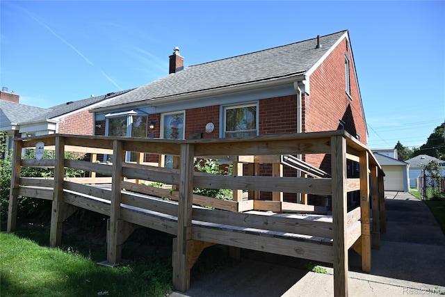1431 Moran Ave, Lincoln Park, MI 48146 - back of house with a shingled roof, a chimney, brick siding, a wooden deck, and an outbuilding