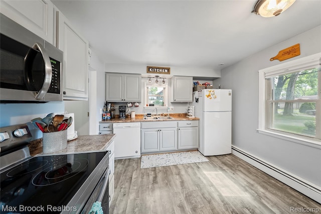 888 Mallock Rd, White Lake, MI 48386 - kitchen featuring stainless steel appliances, a baseboard radiator, healthy amount of natural light, and light wood-style floors