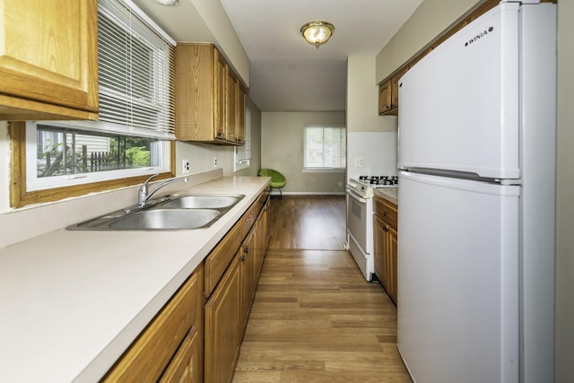 241 Dakota Ave, Ypsilanti, MI 48198 - kitchen with white appliances, light wood-style flooring, light countertops, and brown cabinets