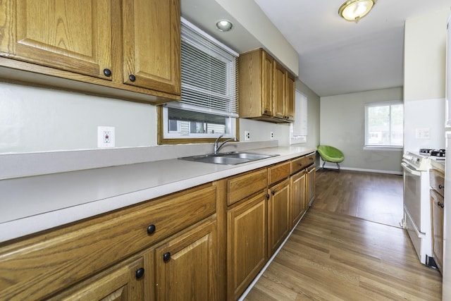 241 Dakota Ave, Ypsilanti, MI 48198 - kitchen featuring white gas range oven, wood finished floors, brown cabinetry, and light countertops