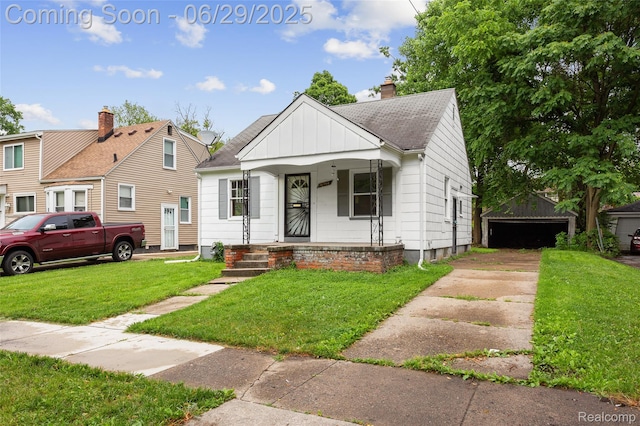16746 Bramell St, Detroit, MI 48219 - bungalow featuring board and batten siding, a porch, a front yard, an outdoor structure, and a chimney