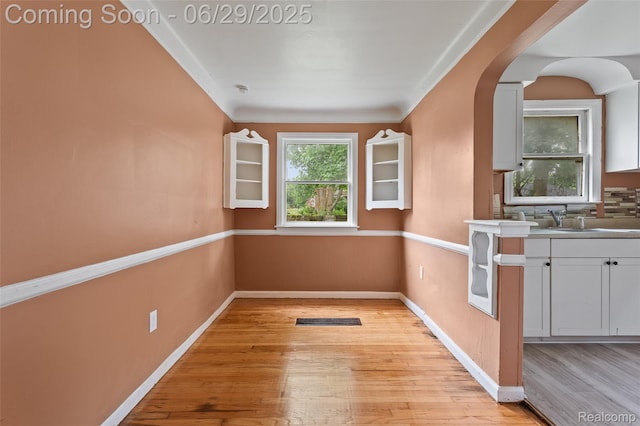 16746 Bramell St, Detroit, MI 48219 - unfurnished dining area with light wood-style floors and arched walkways
