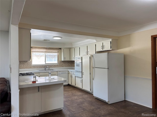 8105 Busch, Center Line, MI 48015 - kitchen with white appliances, a peninsula, decorative backsplash, light countertops, and white cabinetry